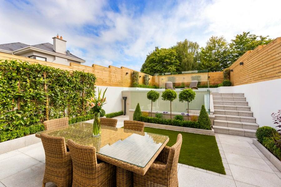 Patio with table and chairs next to a fence